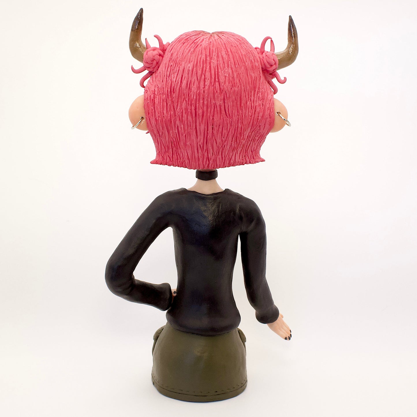 A polymer clay sculpture of the Taurus zodiac personified as a woman, featuring the iconic bull horns, pink hair and grunge/goth piercings, makeup and outfit.