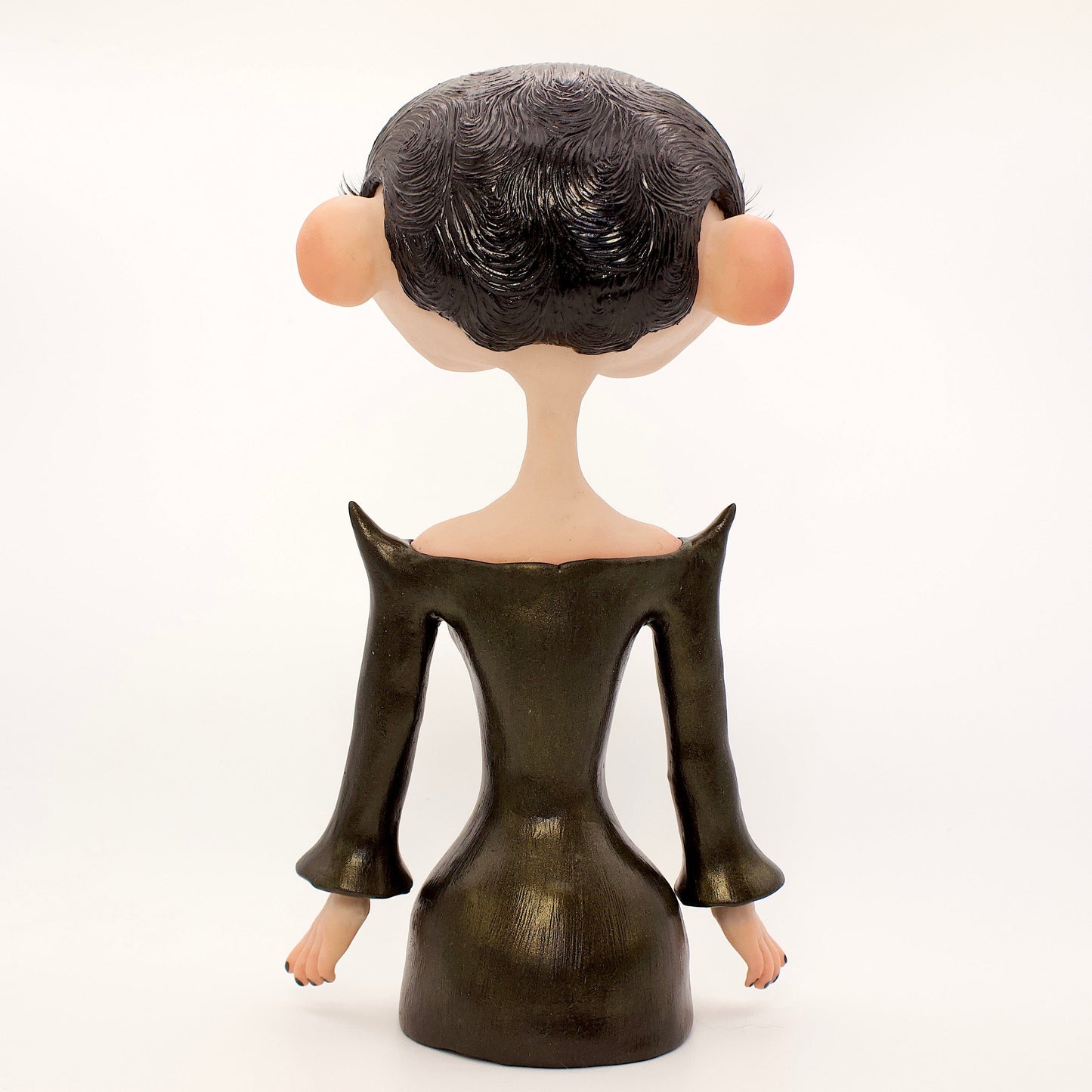 A polymer clay sculpture of the Gemini zodiac personified as a woman, featuring a sleek black dress and two heads fused together, sharing an eye.