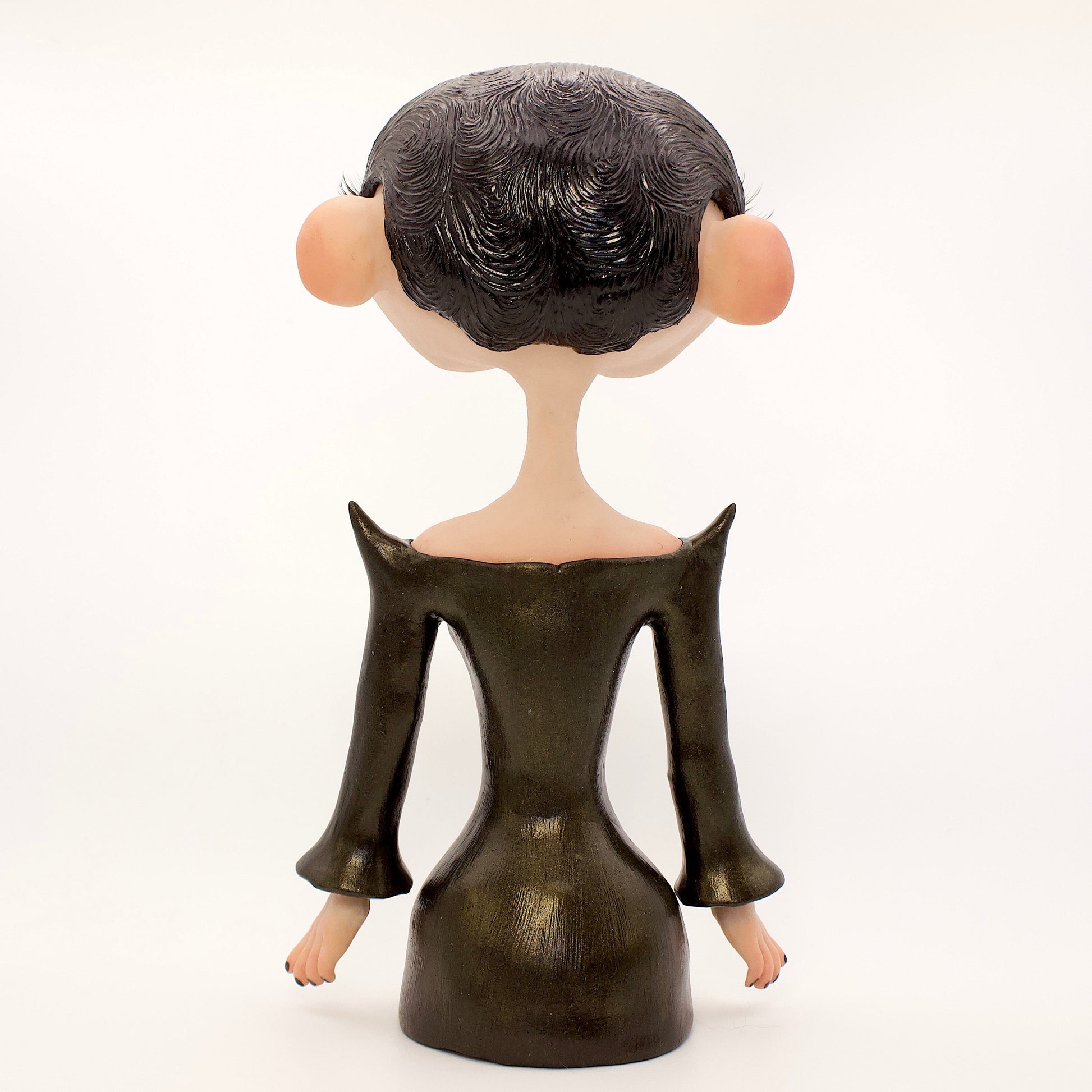 A polymer clay sculpture of the Gemini zodiac personified as a woman, featuring a sleek black dress and two heads fused together, sharing an eye.