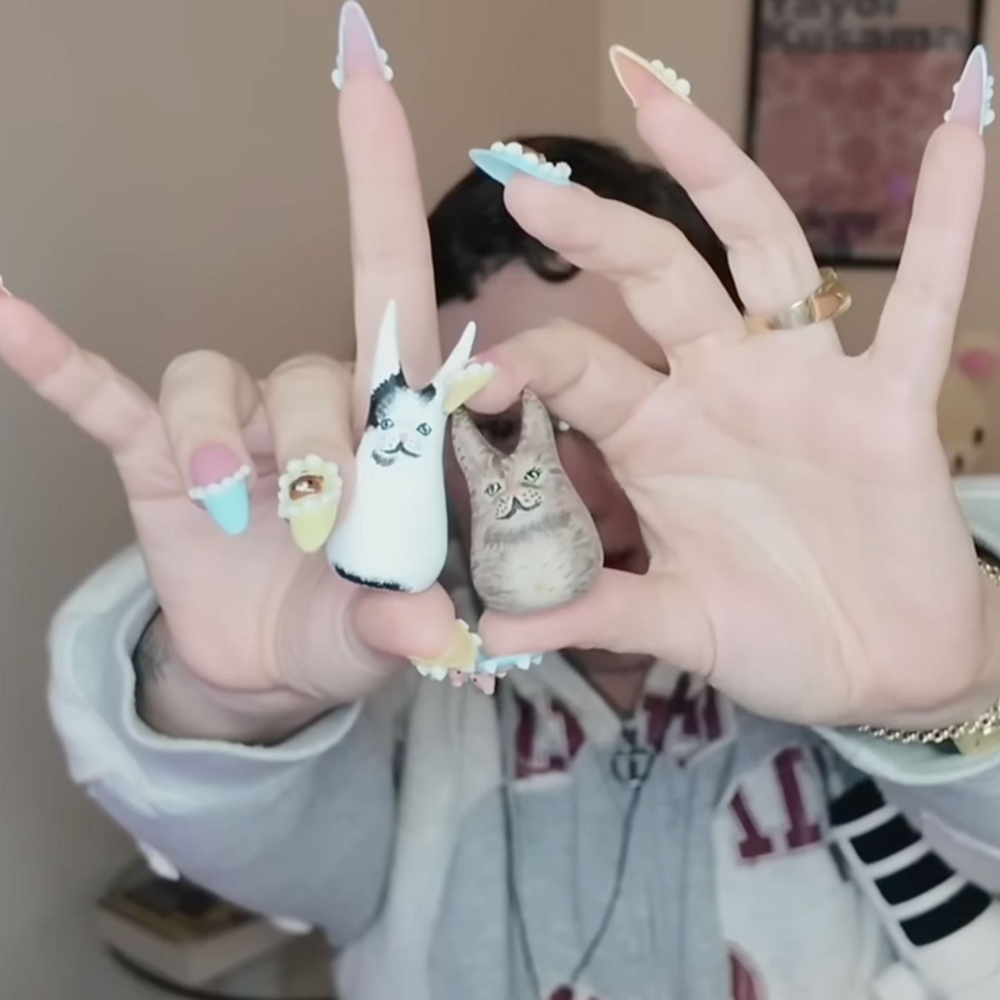 A polymer clay art sculpture of Vanilla Mace's head in a cinamoroll beanie and her two cats, Miso and Chai.