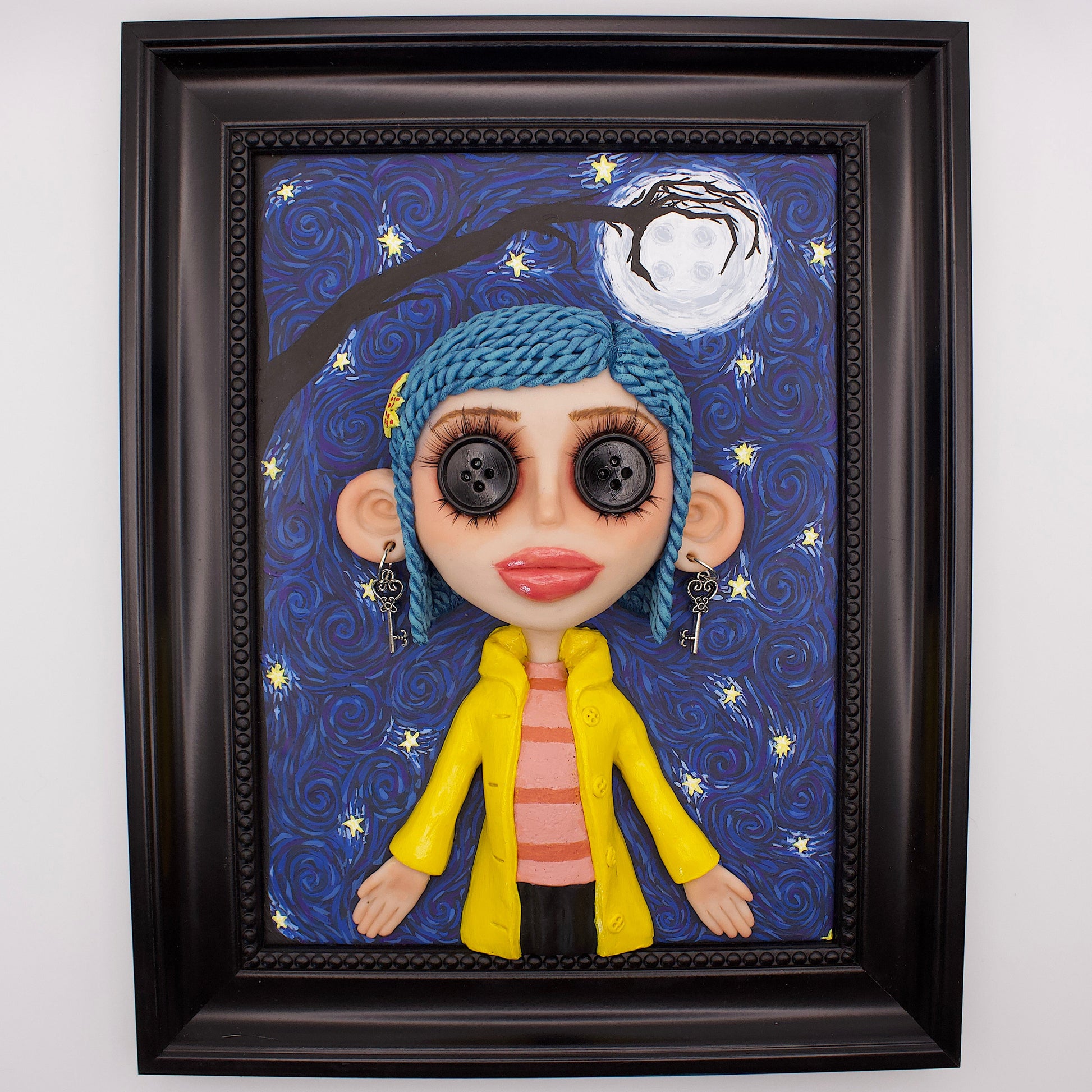A polymer clay sculpture positioned in a black wood photo frame. Featuring the Coraline doll with her iconic button eyes, in her yellow raincoat, set against an impressionistic view of the starry sky with the button moon and a gnarled tree branch in the shape of the other mothers hand. 
